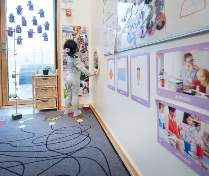 Billedet viser et barn pege på billeder