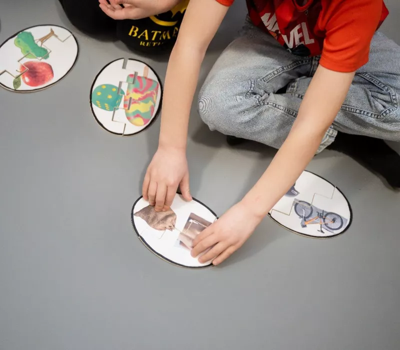 Billedet viser nogle børn lege med kort, der skal blive til sammensatte ord.